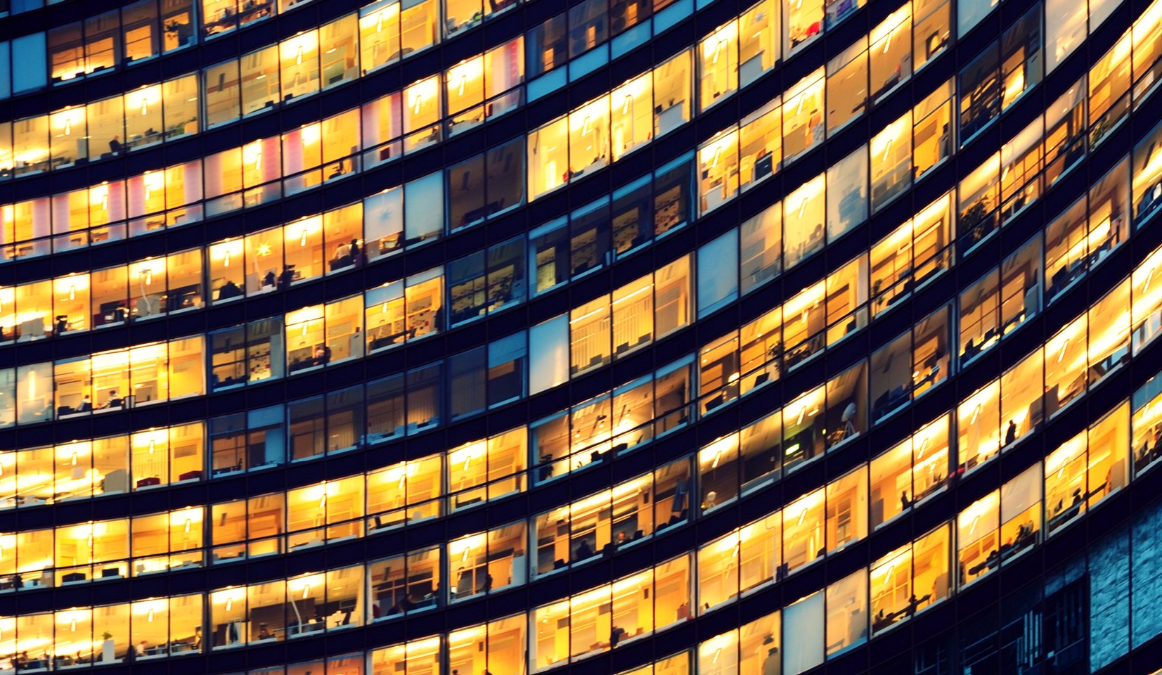 office building windows illuminated yellow at night